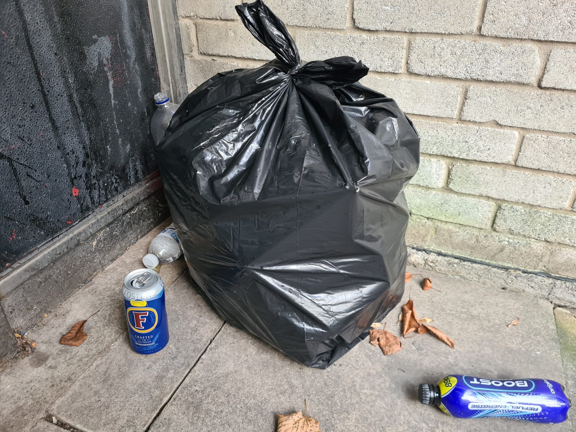 A full bin bag, and empty bottles and cans outside a council estate in Gospel Oak.