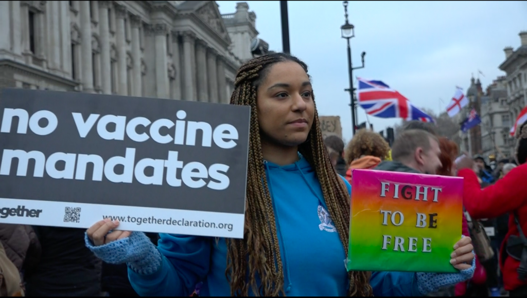 A student protestor holds placards in support of unvaccinated NHS workers at a VCOD protest on Saturday 22nd January 2022