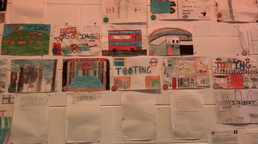 Children's drawing and posters displayed on a wall