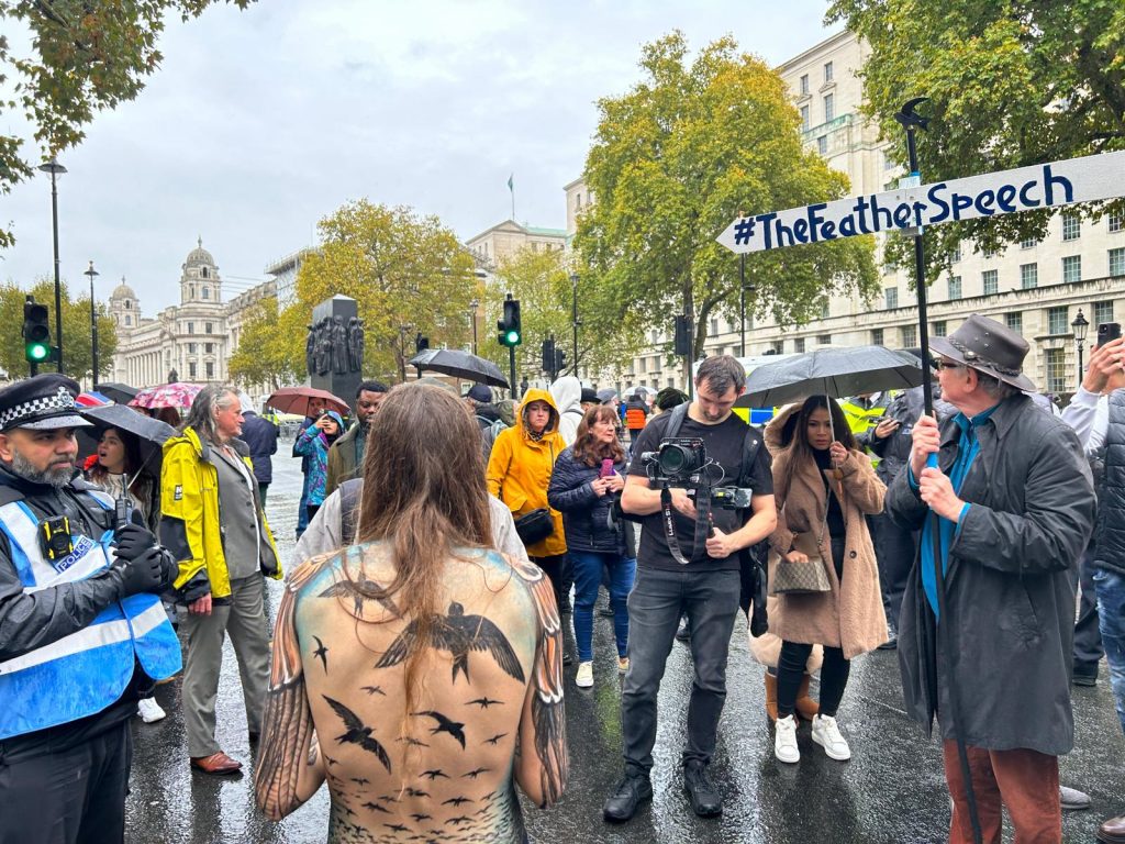 Hannah's back is painted with swifts as she addresses crowds in London